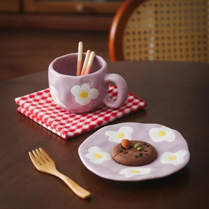 Detail of lavender ceramic cup and saucer set with floral pattern in a cozy setting