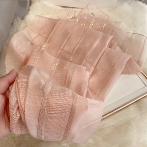 Close-up of soft pink silk wool scarf featuring elegant metallic gold stripes texture