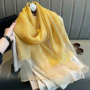 Detail of yellow silk scarf draped elegantly with a soft sheen and airy chiffon texture