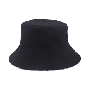 Détail d'un chapeau bob en coton noir uni avec des surpiqûres sur le bord sur fond blanc