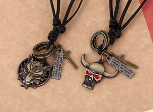 Detail of vintage wolf and skull charms on leather cord with engraved metal tags