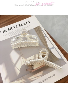 Macro detail of large transparent acrylic hair claws with elegant pearl decorations
