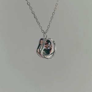 Close-up of a 925 silver necklace with irregular geometric overlapping ring pendants