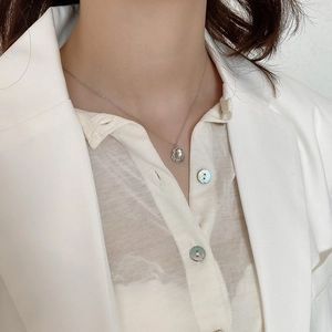 Detail of minimalist 925 sterling silver irregular geometric pendant on a thin chain