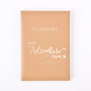 Close-up of light brown PU leather passport cover with gold embossed adventure quote