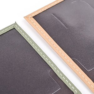Detail of plain PU leather passport cover with precision green and khaki contrast stitching