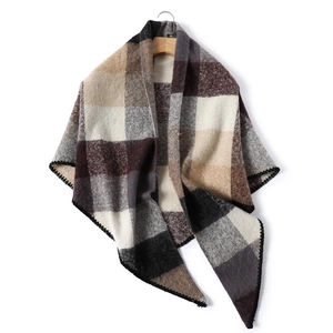 Detail of soft cashmere-like brown plaid scarf with high-quality black lockstitched edges