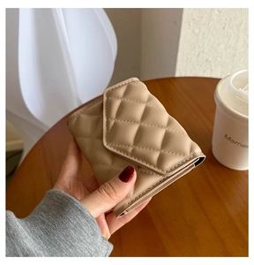 Close-up of a beige quilted leather folding wallet with precise diamond stitching texture