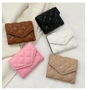 Detailed flat lay of quilted leather mini bags in brown, black, white, pink, and khaki
