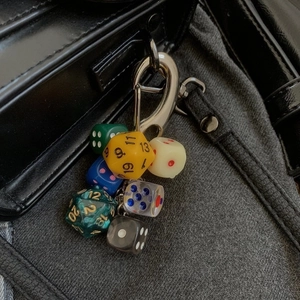 Trendy lucky dice keychain with colorful polyhedral d20 and d6 hanging on a bag