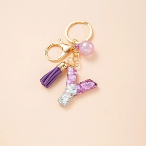 Detail of purple glitter resin letter Y keychain with purple tassel and gold hardware