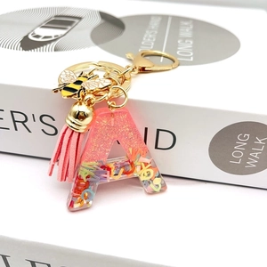 Pink glitter resin letter A keychain with golden bee charm and suede tassel accessory