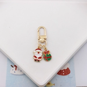Close-up of Christmas keychain with Santa Claus and gift box charms in gold finish