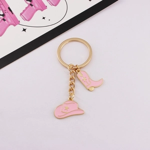Detailed view of pink western cowboy hat and boot keychain with golden alloy hardware