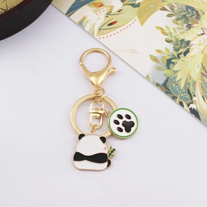 Cute panda keychain with enamel panda eating bamboo and a green paw print charm