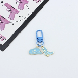 Detail of blue cowboy hat and boot charms on key ring with star accents and gold trim