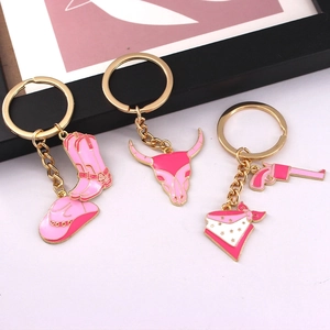Pink western cowboy keychain set featuring cowboy boots, hat, bull skull and revolver charms