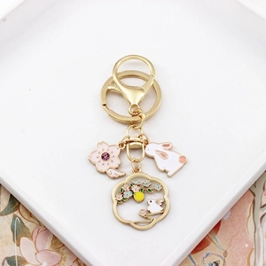 Detail of golden cherry blossom keychain with white rabbit and pink flower charms