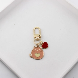 Cute pink cartoon cat enamel keychain with a heart pendant and gold metal hardware