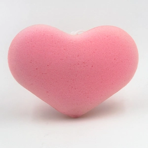 Pink heart-shaped bath sponge with porous texture and white hanging string on white background