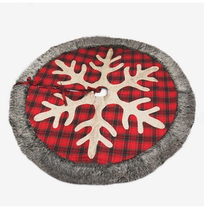 Detail of red and black plaid Christmas tree skirt with beige snowflake and faux fur trim