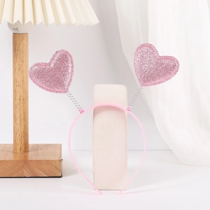 Close-up of pink glitter hearts on spring headband with soft light background