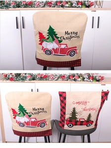 Detail of burlap Christmas chair covers with Santa, pine trees, and red truck patterns