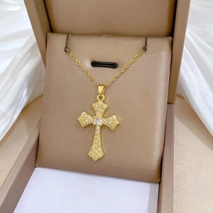 Elegant gold cross pendant necklace with sparkling crystals on silk background