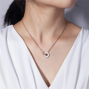 Détail du collier en titane or rose avec anneaux gravés de chiffres romains sur modèle