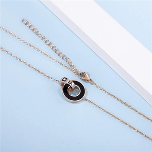 Détail du collier en acier titane rose doré avec pendentif entrelacé à chiffres romains