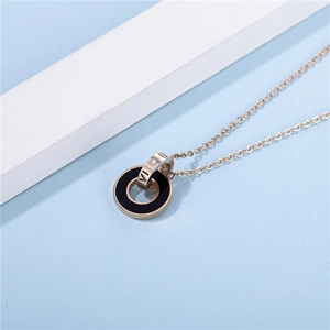 Détail du pendentif double anneau en or rose avec insert noir et chiffre romain VI gravé