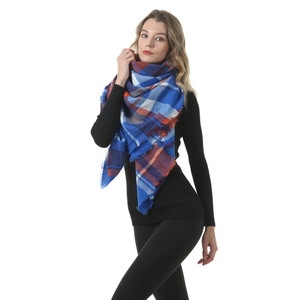 Detail shot of the blue and orange plaid scarf with fringe edge on a model