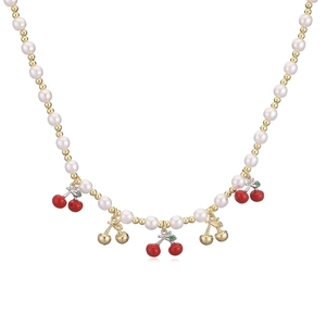 Close-up of pearl bead necklace with red cherry pendants and gold metallic accents
