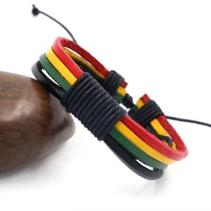 Multilayer braided leather bracelet in Jamaica Reggae colors on a dark wooden stand