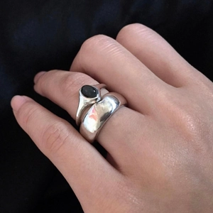 Close-up of 925 sterling silver couple rings set with black onyx gemstone on hand