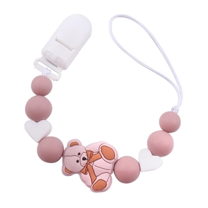 Detail of pink silicone pacifier clip with cartoon bear pendant and heart beads