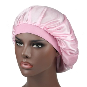Pink silky satin bonnet cap with wide elastic hair band for night hair care on head mannequin