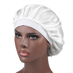 Close-up of a white silky satin sleep bonnet with wide elastic band on a model