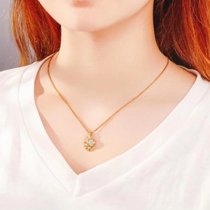 Elegant gold sun pendant necklace with sparkling crystals worn by model for fashion look