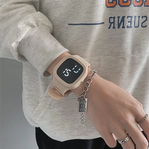 Wrist shot of a beige silicone square digital watch with white LED time display