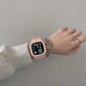 Pink digital LED sports watch with silicone strap showing time and date on wrist