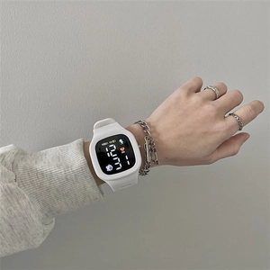 Close-up of white LED digital watch with silicone strap on wrist showing time and date