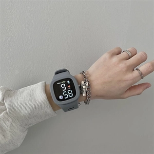 Close-up of a gray LED touch screen sports watch with silicone strap on a wrist