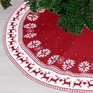 Detail of red knit Christmas tree skirt featuring white reindeer and snowflake patterns