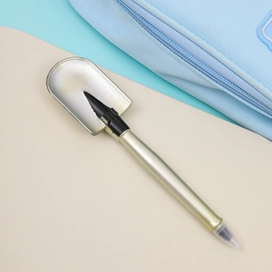 Macro shot of creative shovel-shaped ballpoint pen in champagne gold with clear cap