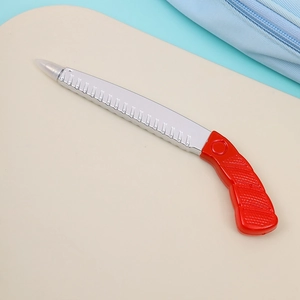 Detailed close-up of a novelty hand-saw shaped ballpoint pen with a red handle