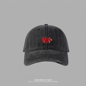 Detail of washed black baseball cap featuring red crying heart embroidery and frayed brim