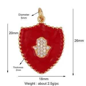 Detailed view of gold Hamsa Hand shield pendant with red enamel and zircon inlay