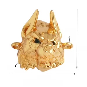 Macro view of gold-plated wolf head bead with green zircon eyes for DIY jewelry