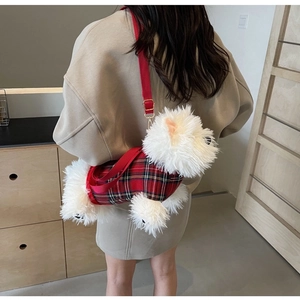 Detail of cartoon dog plush bag featuring red plaid fabric and adjustable strap
